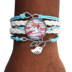 Stylish Unicorn Charm Bracelet on wrist featuring braided white and blue faux leather strands and silver-tone unicorn and bird charms.