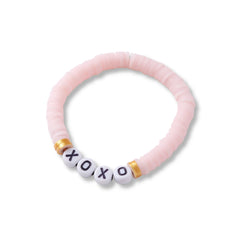 Close-up of pastel pink Cotton Candy Bracelet with XOXO letter beads and gold accents, part of a trendy stackable set.