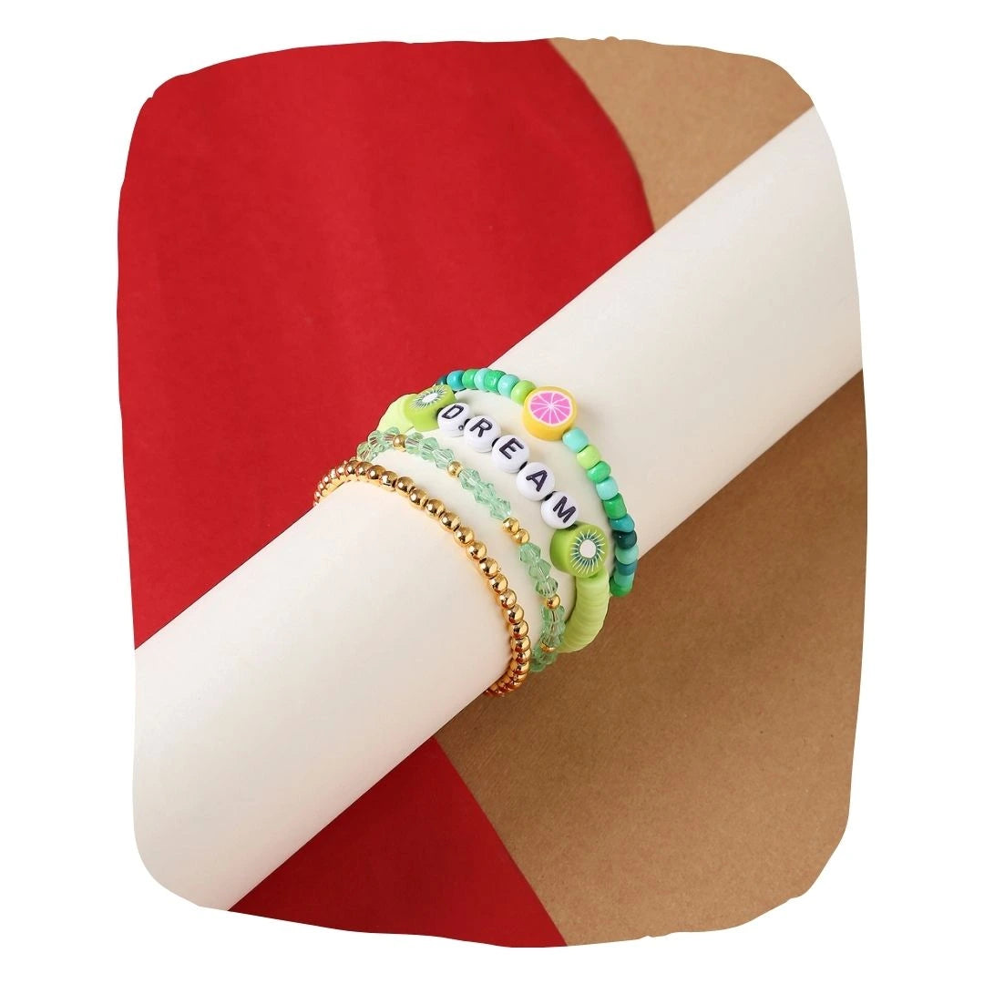 Matcha Bliss Bracelets - Trendy Clay Bead Teens | Stackable Set of 4 with 'DREAM' charm and citrus-themed accents on display roll.