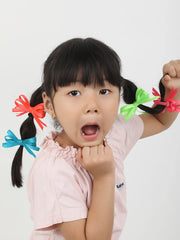 Young girl playfully styled with handmade neon hair bows featuring secure clips, perfect for girls' playful and stylish looks.