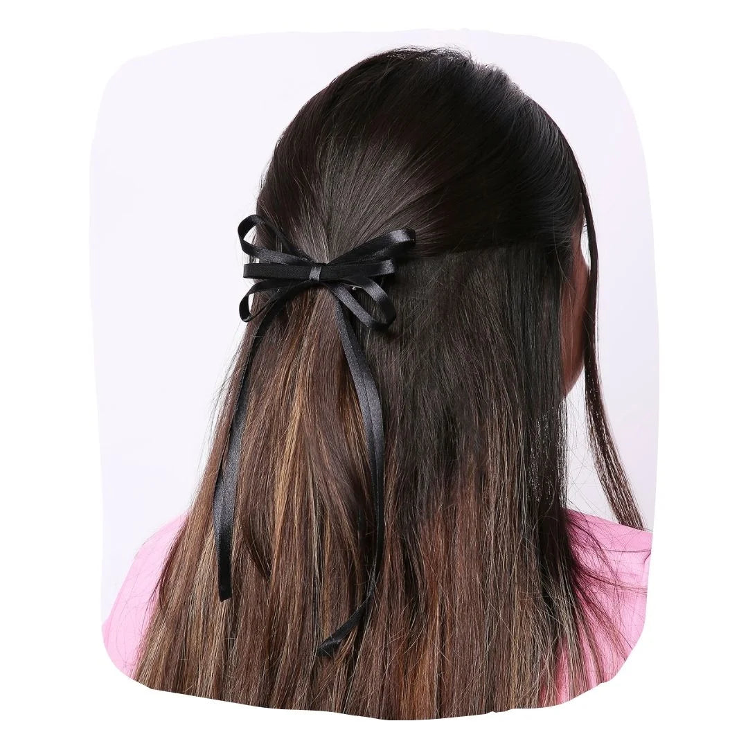 Elegant Handmade Satin Silk Hair Bow in black styled on long brown hair. Adds charm and comfort to women's hairstyles for any occasion.