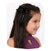 Black satin silk ribbon hair bow styled on a young girl with braided hair. Handmade accessory ideal for kids' elegant hairstyles.