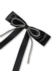 Close-up of black satin hair bow with sparkling rhinestone trim. Handmade design perfect for formal or casual wear.