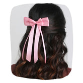 Pink satin silk ribbon hair bow styled on wavy hair, ideal for women and kids. Handmade accessory adds charm to casual or festive outfits.