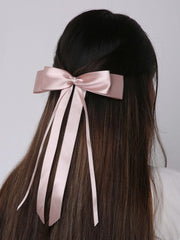 Blush pink satin silk ribbon bow worn on straight hair. A stylish and secure hair accessory for women and kids, perfect for gifting.