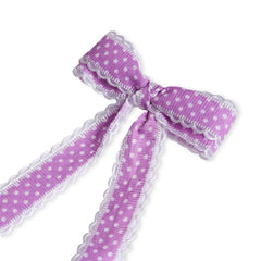 Close-up of lavender grosgrain polka dot hair bow with white scalloped trim. Handmade clip for secure, stylish wear.