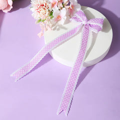 Lavender grosgrain polka dot hair bow with long tails on display. Handmade accessory ideal for girls' stylish looks.