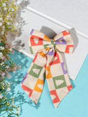 Festive Arendelle Christmas hair bow displayed on white board with floral decor. Bright holiday colors perfect for seasonal outfits.