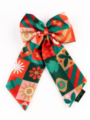 Close-up of vibrant Christmas hair bow featuring red, green, and gold holiday motifs. Stylish and durable accessory for festive celebrations.