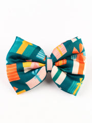 Close-up of Christmas Gift Hair Bow featuring vibrant gift box patterns on green fabric, ideal for holiday hair accessories for girls.