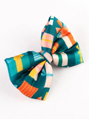 Angled view of Christmas Gift Hair Bow with colorful present print, showcasing its festive design for seasonal hair styling.