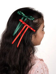Girl showcasing green and red Arendelle Christmas hair bows, ideal for festive styling with secure alligator clips.