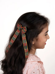 Girl showcasing Arendelle's plaid Christmas hair bow for girls, a trendy and secure holiday accessory for ages 3 to 12.
