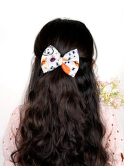 Girl wearing White Halloween Hair Bow with skull, stars and autumn leaves