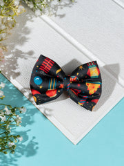 Diwali Fireworks Hair Bow placed on textured white board with floral accents. Vibrant festive design for girls' hair accessories.