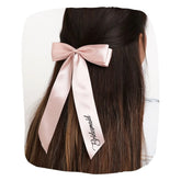Elegant satin bridesmaid bow in blush pink worn on long hair, perfect for weddings and special occasions. Reusable and stylish hair accessory.