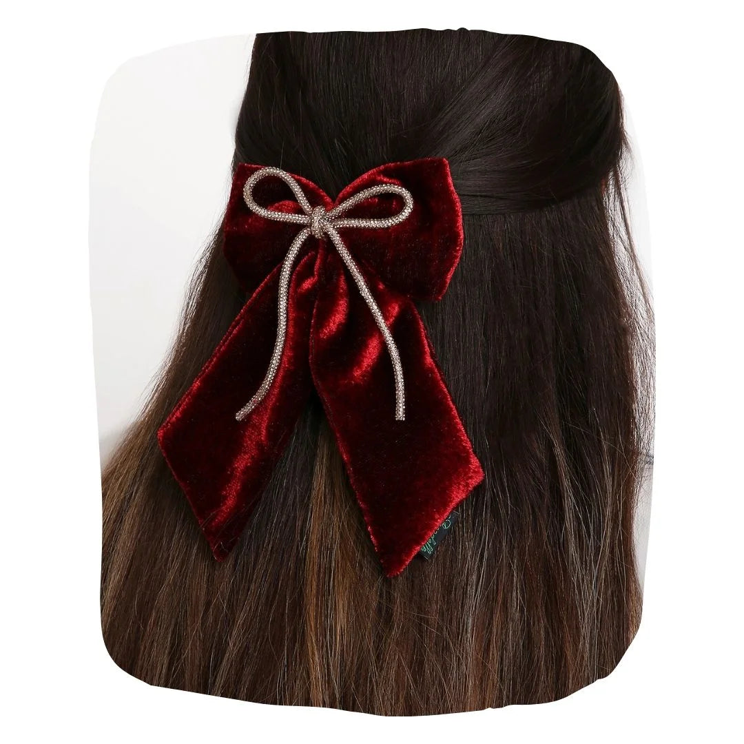 Maroon velvet hair bow with rhinestone cord styled on long dark hair, secured with a sturdy clip for an elegant look.
