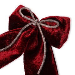 Close-up of maroon velvet hair bow featuring a sparkling rhinestone cord, showcasing its plush texture and fine detailing.