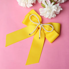 Yellow Pearl Beaded Hair Bow on pink background, featuring grosgrain ribbon and pearl loop, perfect for gifting or daily wear.