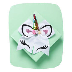 White Unicorn Cheer Bow for Girls with glitter horn, pink ears, and floral accents on a mint gift box. Stylish 7-inch hair accessory for kids.