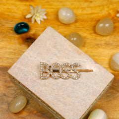 Trendy 'BOSS' Hair Clip by Arendelle displayed on a wooden block with decorative stones, perfect for stylish girls' hair accessories collection.