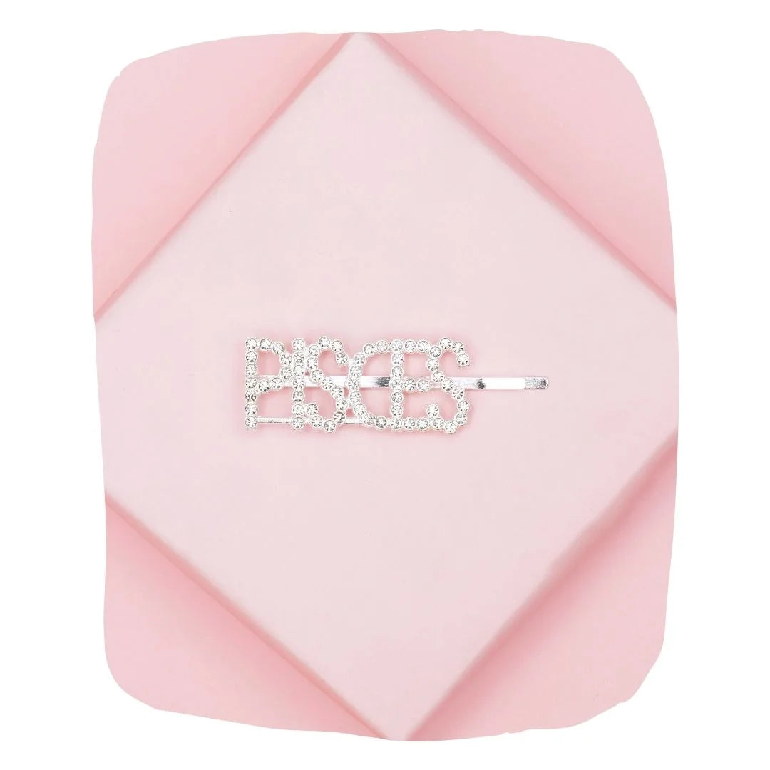 Pisces Rhinestone Hairpin on pink background, featuring sparkling crystals in zodiac lettering for stylish hair accessory with secure grip.
