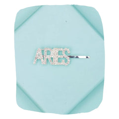Silver glitter ARIES hairpin with rhinestone lettering on a blue background, perfect for zodiac-themed hair styling.