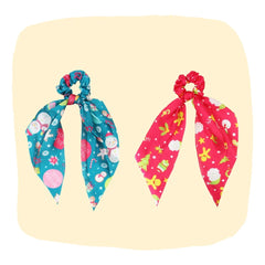 Arendelle Christmas Hair Scrunchies for Girls in festive blue and red satin with snowman, reindeer, and holiday prints. Ideal for holiday outfits.