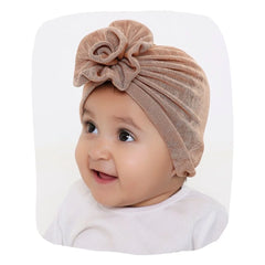 Soft baby turban cap in shiny brown with front knot, stretchable and comfy for newborns and toddlers. Ideal hair accessory for girls aged 0 to 2 years.