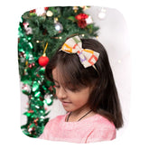 Yellow Bow Baby Headband with pastel Christmas tree print worn by a girl, perfect for festive outfits and toddler holiday accessories.