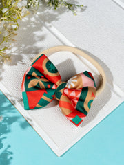Christmas Baby Headband - Soft & Stretchable | Trendy Designs featuring a red geometric bow on a beige elastic band, styled for festive occasions.