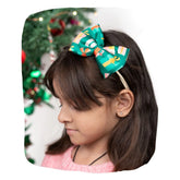Christmas baby headband with green bow featuring colorful gift print, worn by a young girl, ideal for festive outfits and holiday photos.
