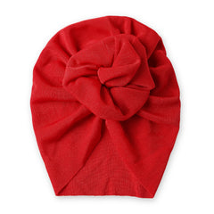 Top view of Red Baby Turban Cap with stylish central knot, made from soft stretchable fabric for comfort and elegance.