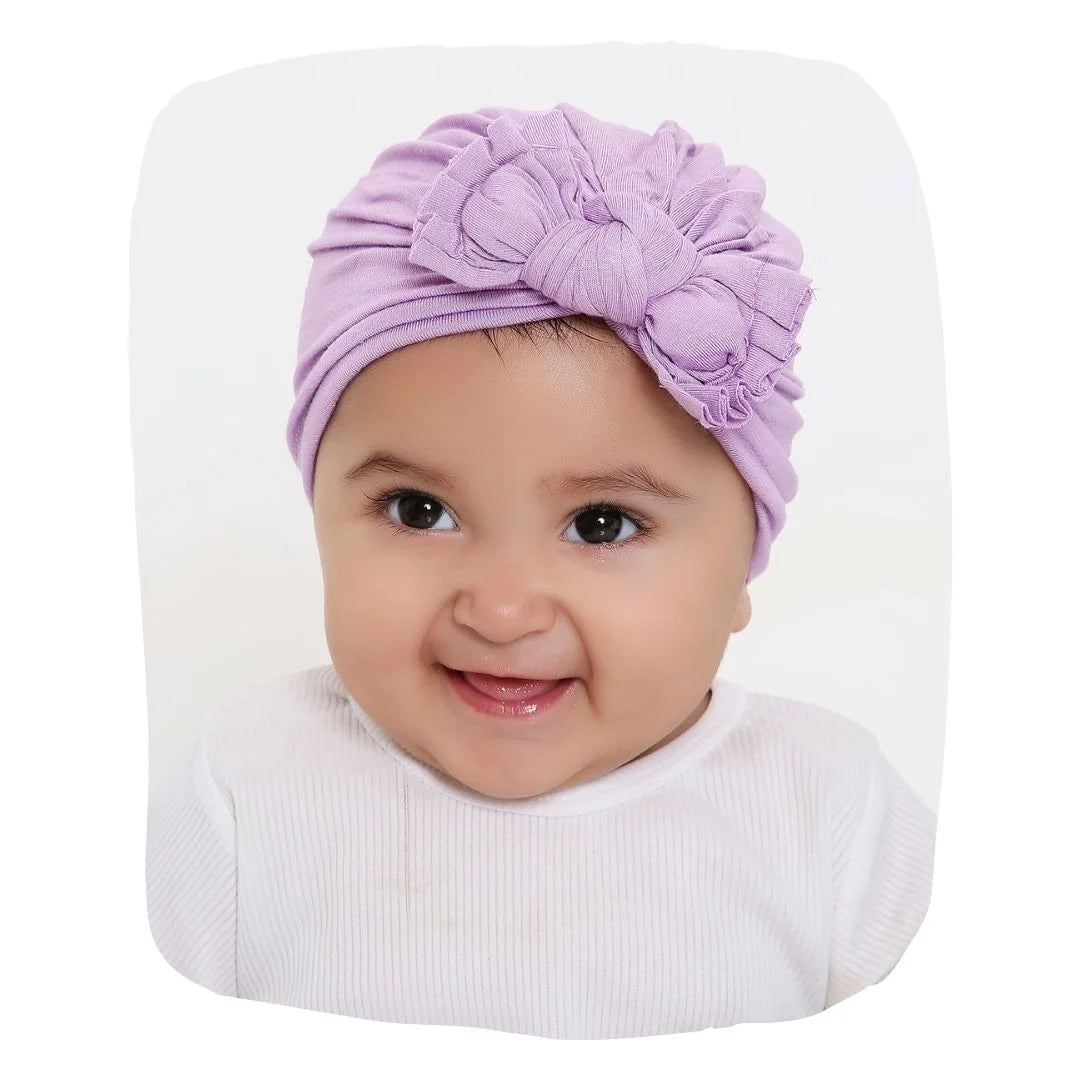 Cotton Baby Turban - Purple Knot styled on smiling baby girl, soft and breathable for newborns to toddlers, ideal for daily wear and photoshoots.