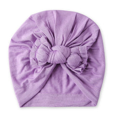 Top view of purple cotton baby turban with large bow knot, stylish and comfortable headwear for girls in trending hair accessories.