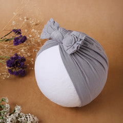 Pure Cotton Grey Bow Knot Baby Turban displayed on mannequin head with floral decor. Perfect cotton baby turban for stylish infant wear.