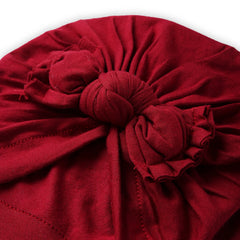 Close-up of maroon cotton bow knot on baby turban. Detailed stitching and soft fabric highlight quality and comfort for newborns.