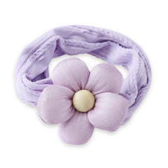 Folded cotton baby headband in soft lilac featuring a plush flower center. Breathable and stretchable for baby girls aged 0 to 2 years.