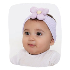 Cotton baby headband in soft lilac with plush flower, worn by baby girl. Ideal for ages 0 to 2 years, combining comfort and style.