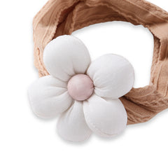 Close-up of soft baby cotton headband in tan with a large white flower, designed for a snug and gentle fit on infant heads.