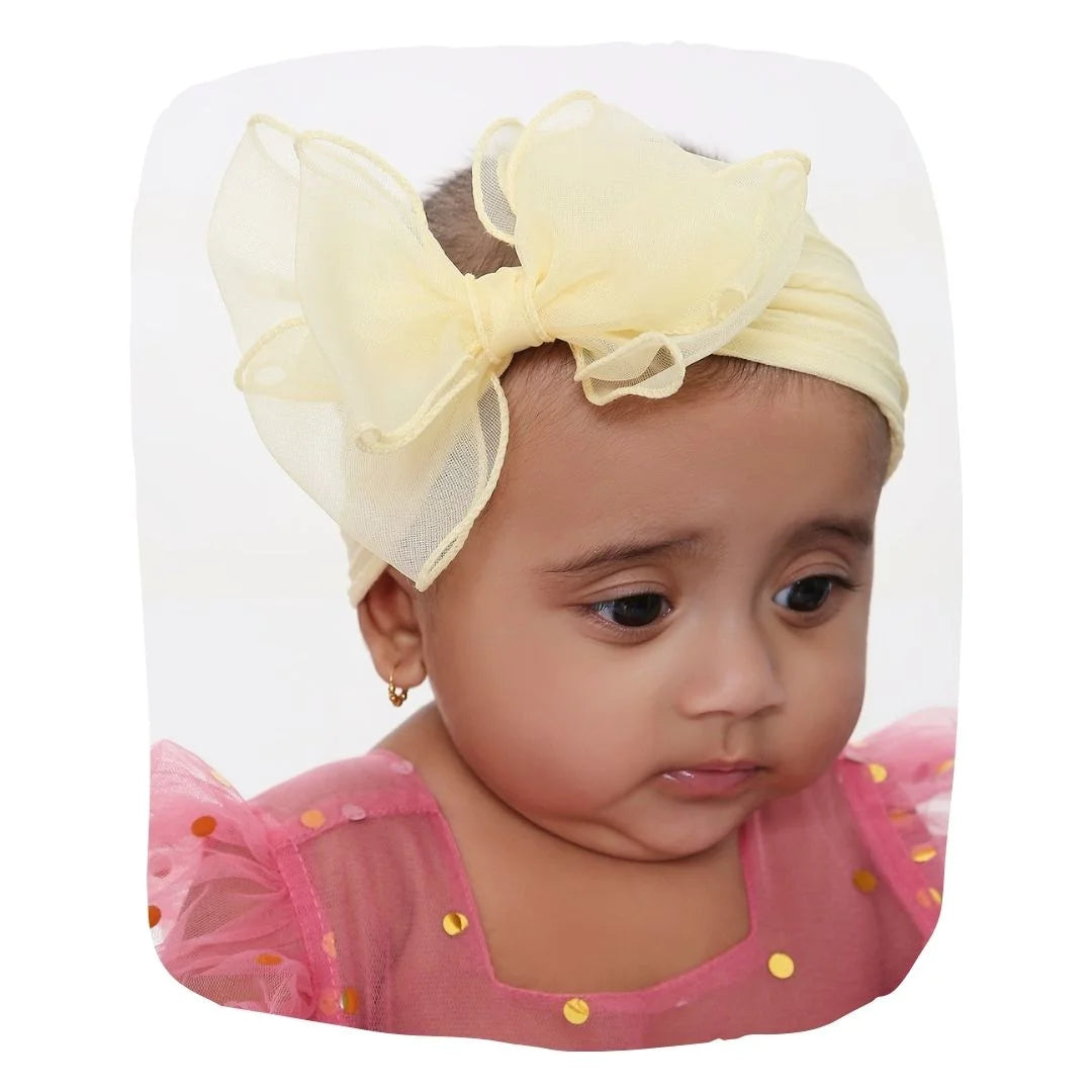 Double Layered Bow Headband in soft yellow cotton with large bow, worn by baby girl. Ideal for newborns and toddlers aged 0 to 2 years.