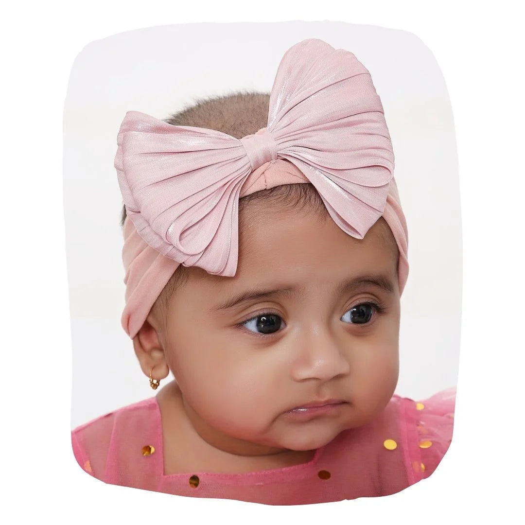 Cotton baby headband bow in rose pink worn by infant girl. Double layered, soft and stretchable for ages 0-2 years, ideal for daily wear.