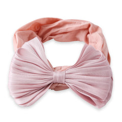 Flat lay of cotton baby headband bow in rose pink. Features a double layered pleated bow and stretchable band for comfort and style.