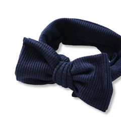 Close-up of Navy Blue Baby Headband in soft cotton with textured fabric and oversized bow, designed for comfort and style for baby girls.
