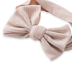 Close-up of light brown cotton baby headband featuring a soft, ribbed bow knot design for newborns and toddlers.