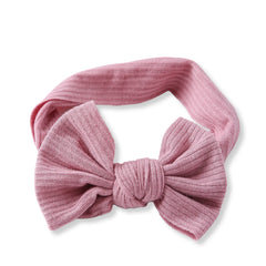 Soft pink cotton baby headband with large knotted bow. Lightweight and breathable hair accessory for girls aged 0 to 2 years.