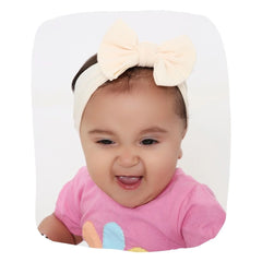 Beige Bow Knot Kids Headband on smiling baby girl, soft cotton headband ideal for newborns and toddlers aged 0 to 2 years.