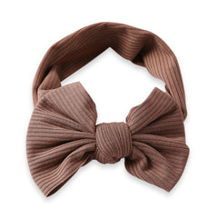 Stretchable brown baby cotton headband with oversized bow, laid flat to show full design. Perfect hair accessory for girls aged 0 to 2 years.