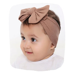 Soft baby cotton headband in brown with large bow, worn by toddler girl. Stylish comfort for 0 to 2 years, ideal for daily or special wear.
