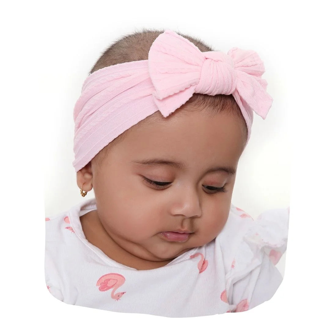 Light pink baby cotton bow headband worn by infant girl, soft and stretchable for newborns, ideal for stylish everyday wear.